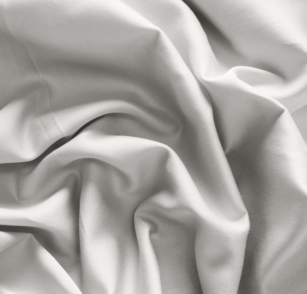Boll & Branch Mist elastic-band detail demonstrates secure fit for standard cribs
