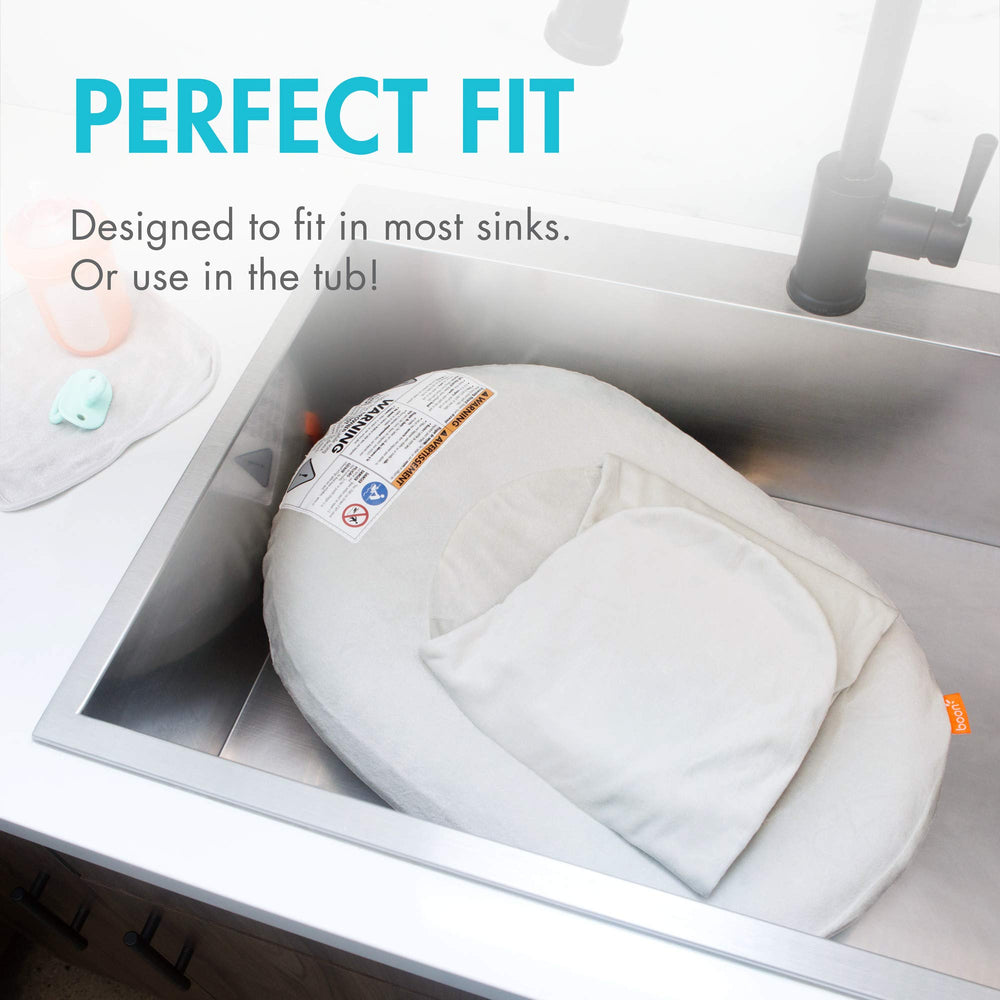 Boon Puff+ swaddle wings cradle baby for secure, comforting baths.