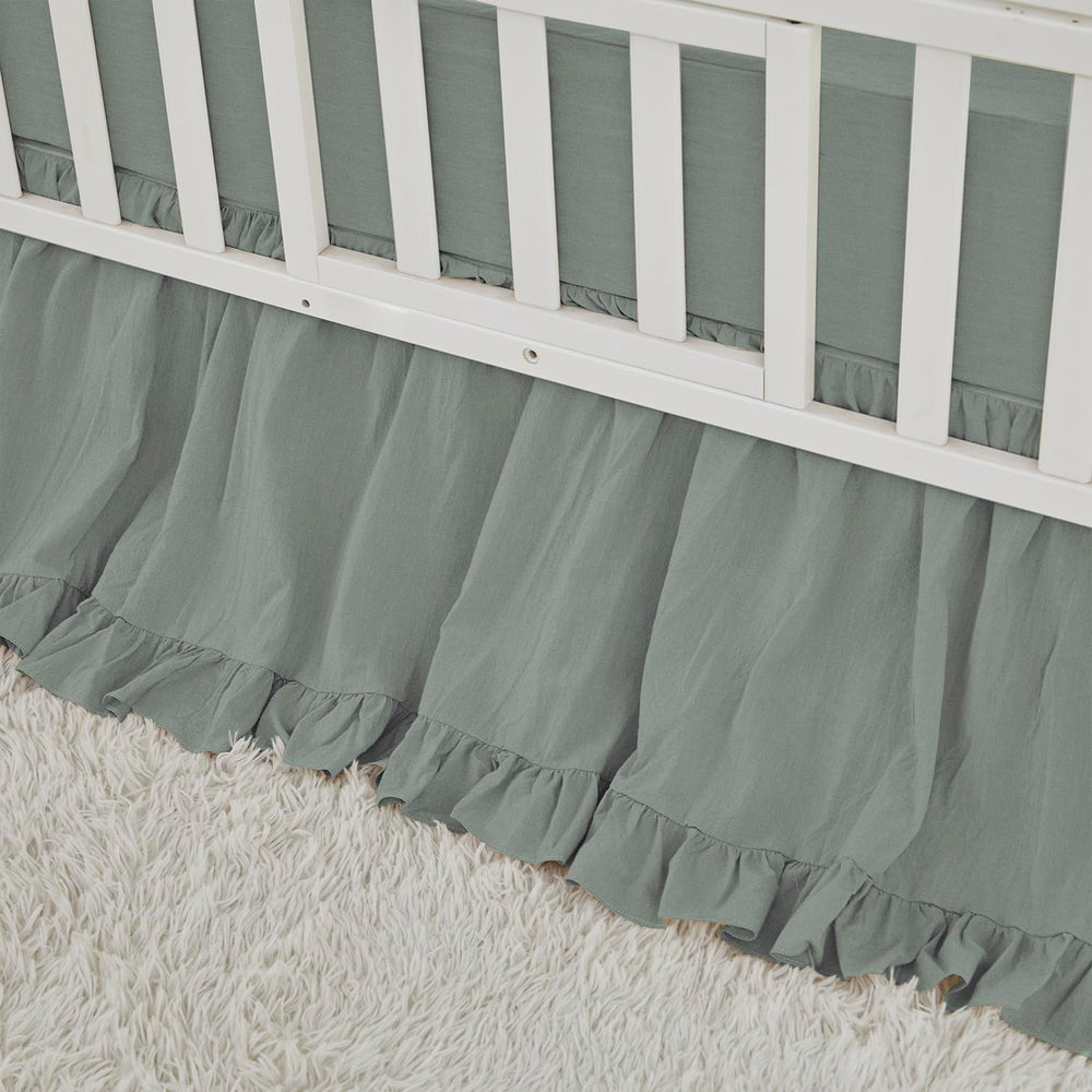 Brandream crib skirt in sage green with ruffles that hide under-crib storage.