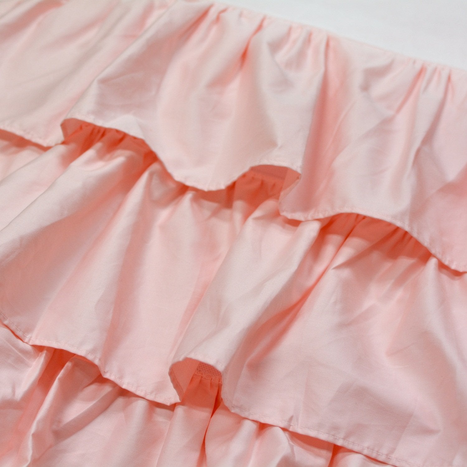 Brandream four-sided triple-layer crib skirt closeup highlighting secure fit around posts and easy placement