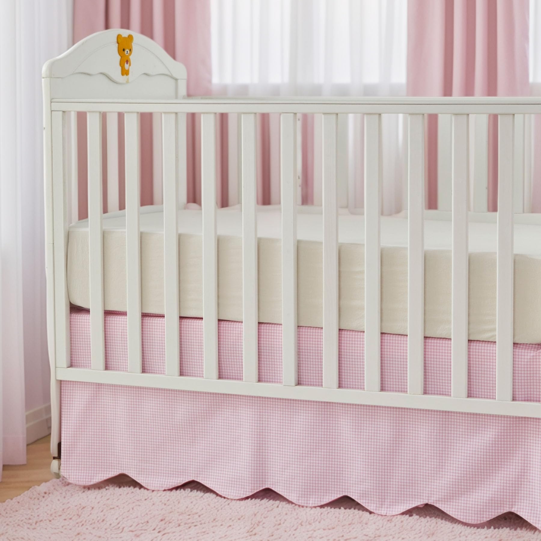 Brandream nursery decor pink gingham skirt paired with neutral furniture.