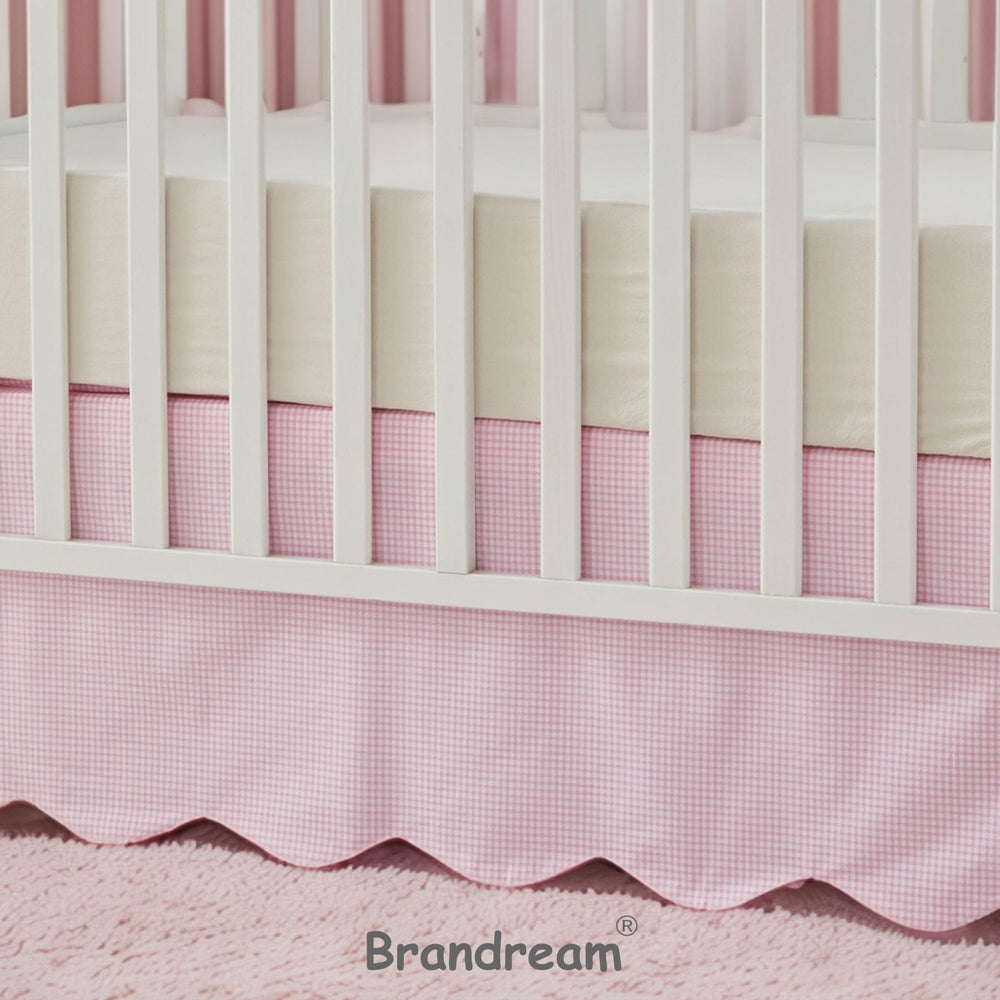 Brandream scallop edge crib skirt on bed demonstrates complete coverage.