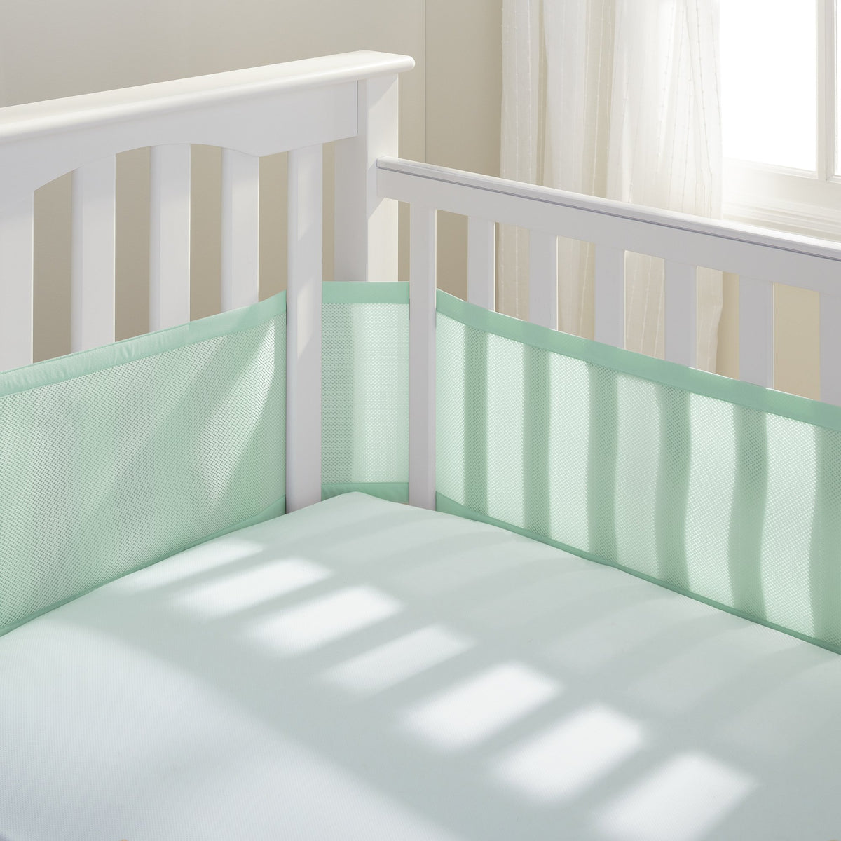 BreathableBaby breathable mesh liner on full-size crib, mint green, four-sided coverage for safe sleep.