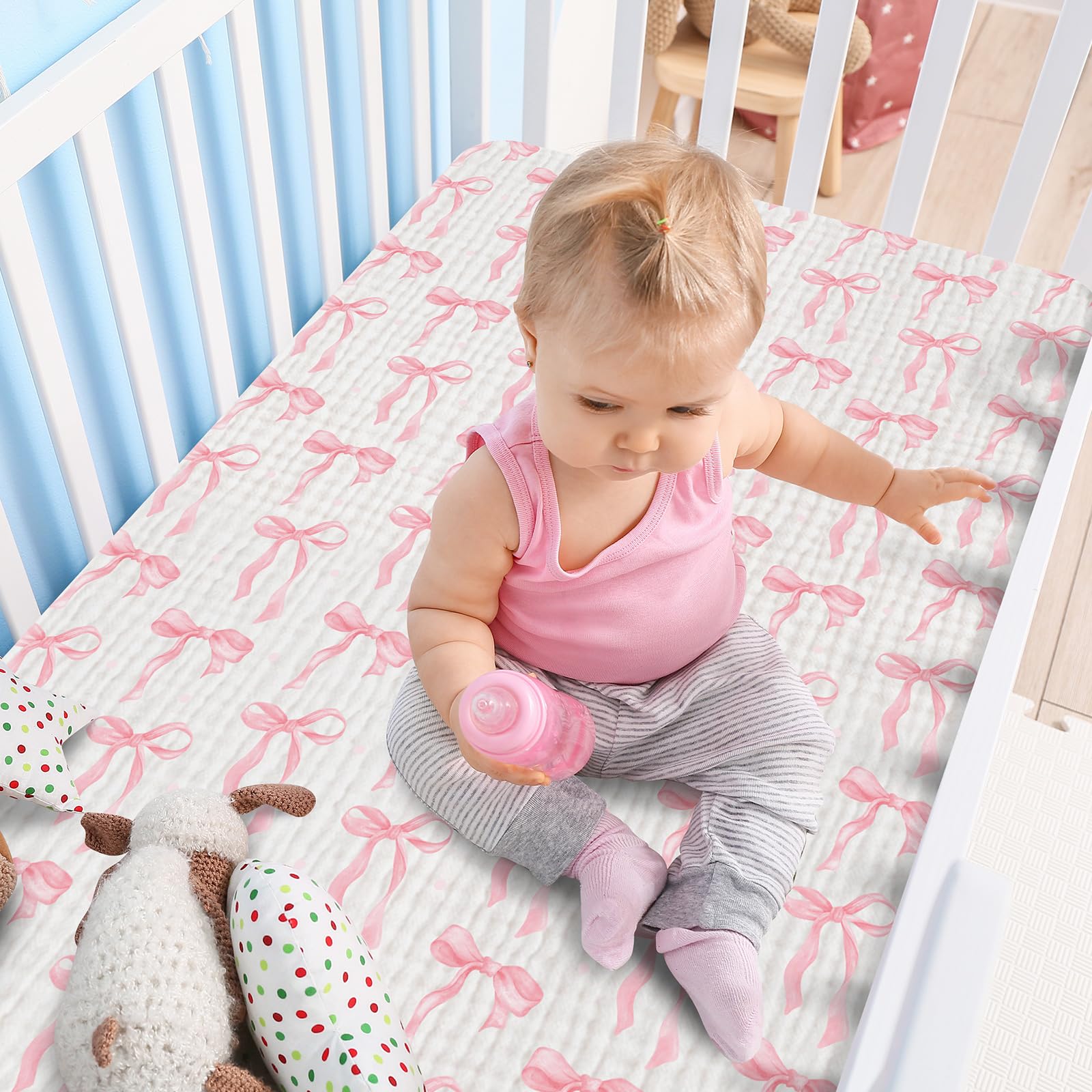 Breling pink bow crib sheets in a nursery setting for coordinated decor