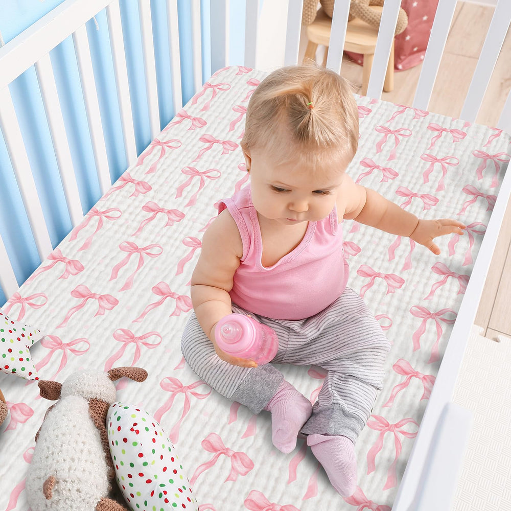 Breling pink bow crib sheets in a nursery setting for coordinated decor