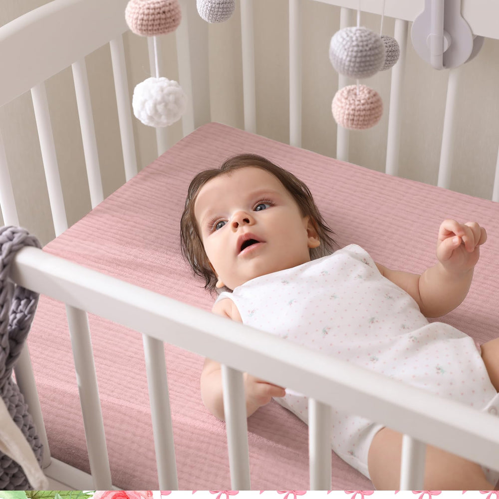 Breling pink bow crib sheets stacked, ready for travel or daycare use