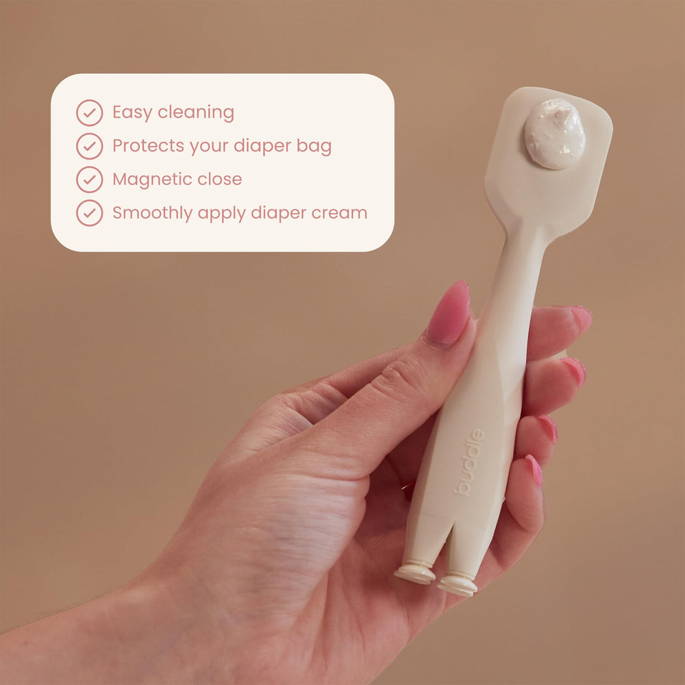 Buddle Paddle Pal in use during a diaper change shows gentle, even cream application.