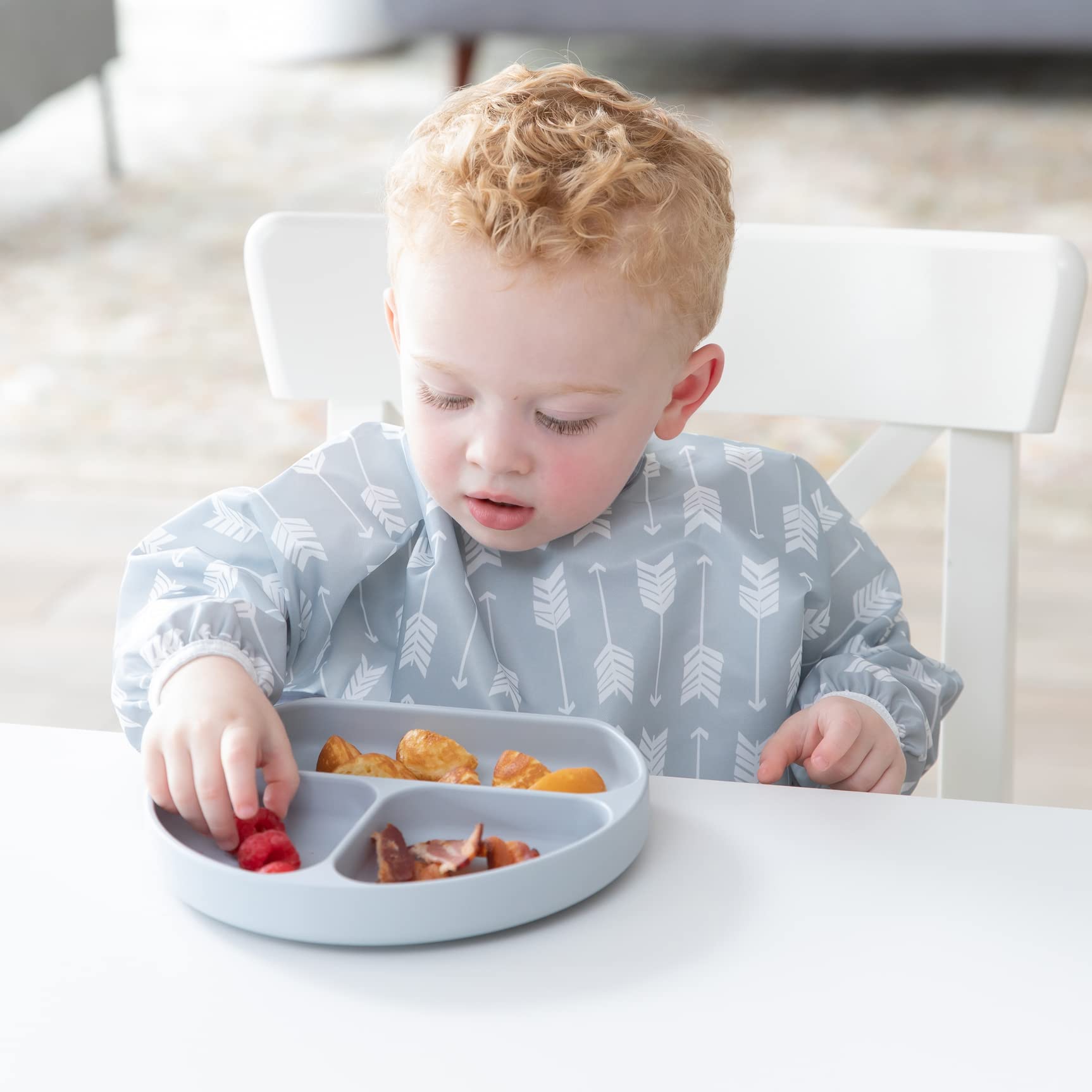 Bumkins sleeved bib gray arrows waterproof fabric resists stains during busy mealtimes.