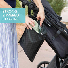 Bumkins wet bag with snap handle attached to stroller for on-the-go use.
