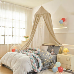 Bunnikins & Clover canopy inside baby crib creating a cozy reading corner.