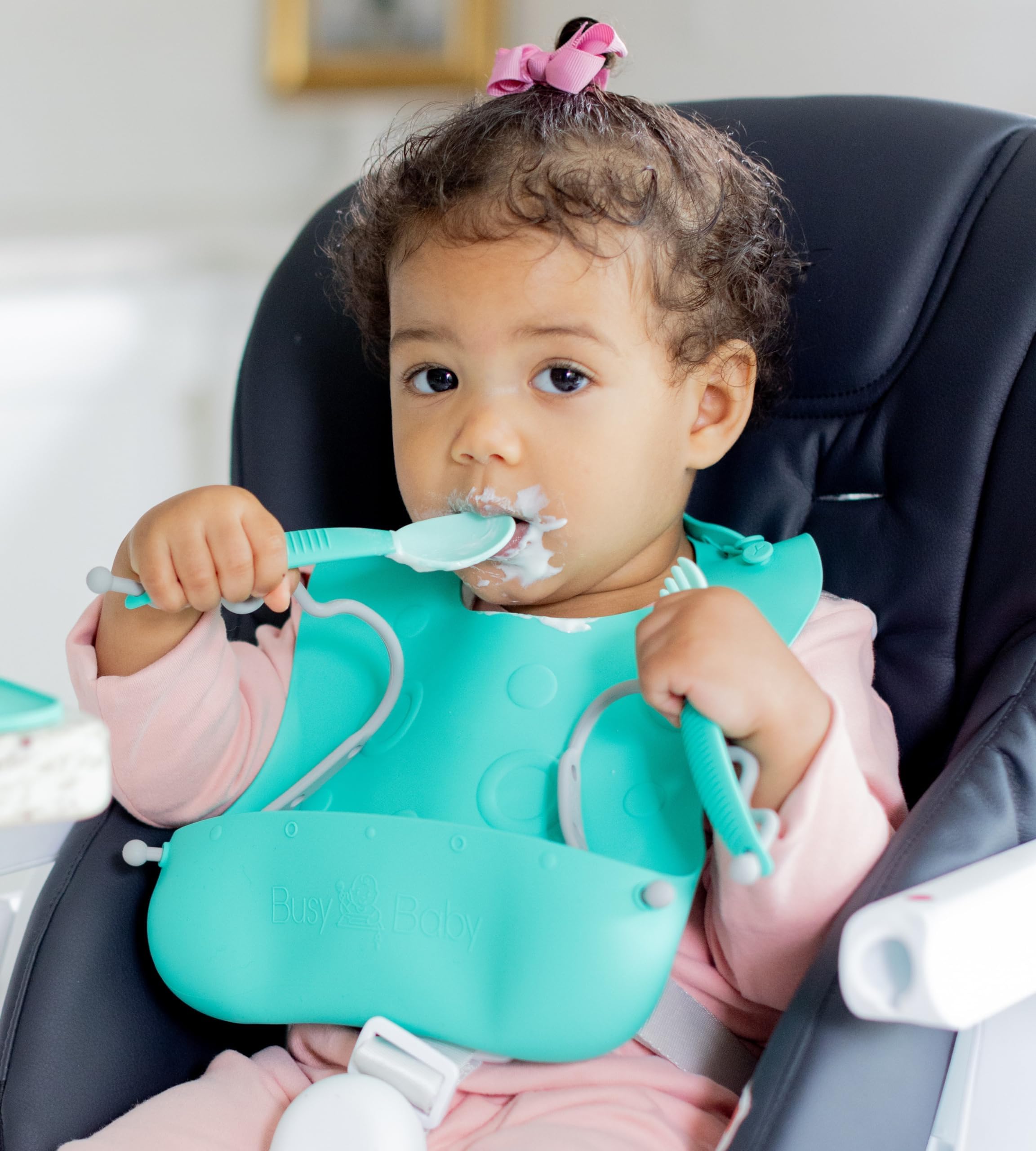 BUSY BABY Bungee Bib on baby mealtime illustrates practical, mess-contained feeding.
