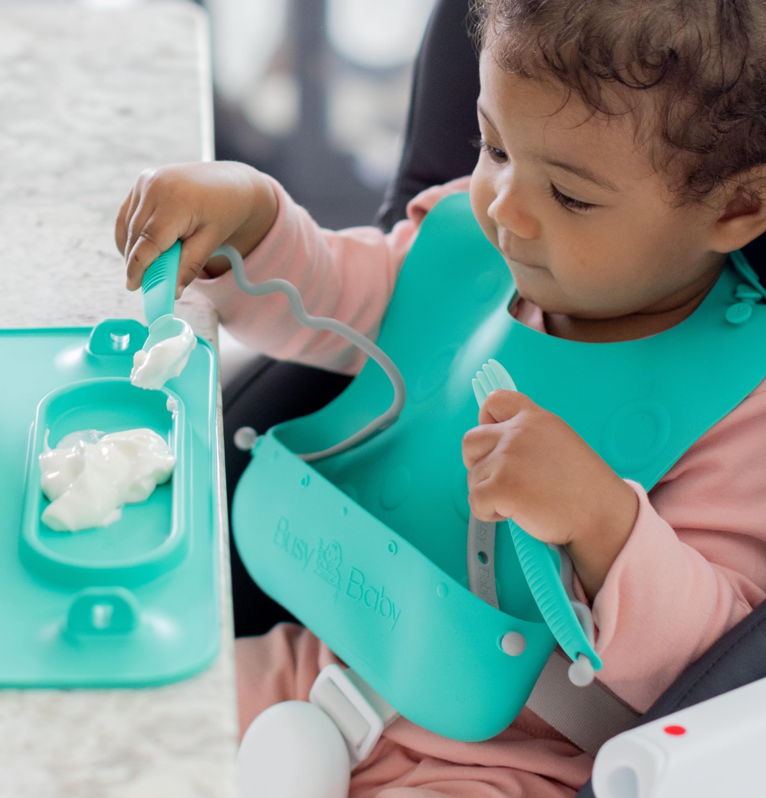 BUSY BABY Bungee Bib pocket mealtime highlights deep pocket catching spills and crumbs.