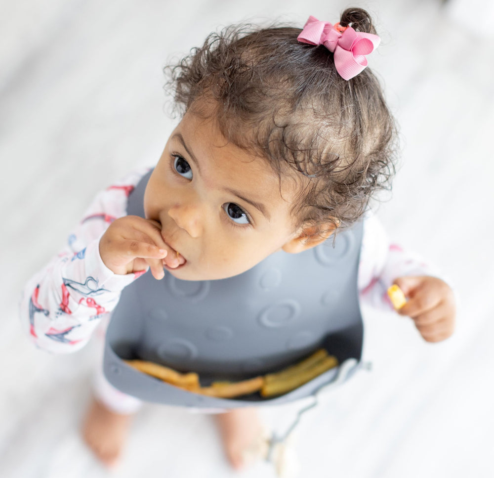 BUSY BABY Bungee Bib rolled storage shows portable, travel-ready design.