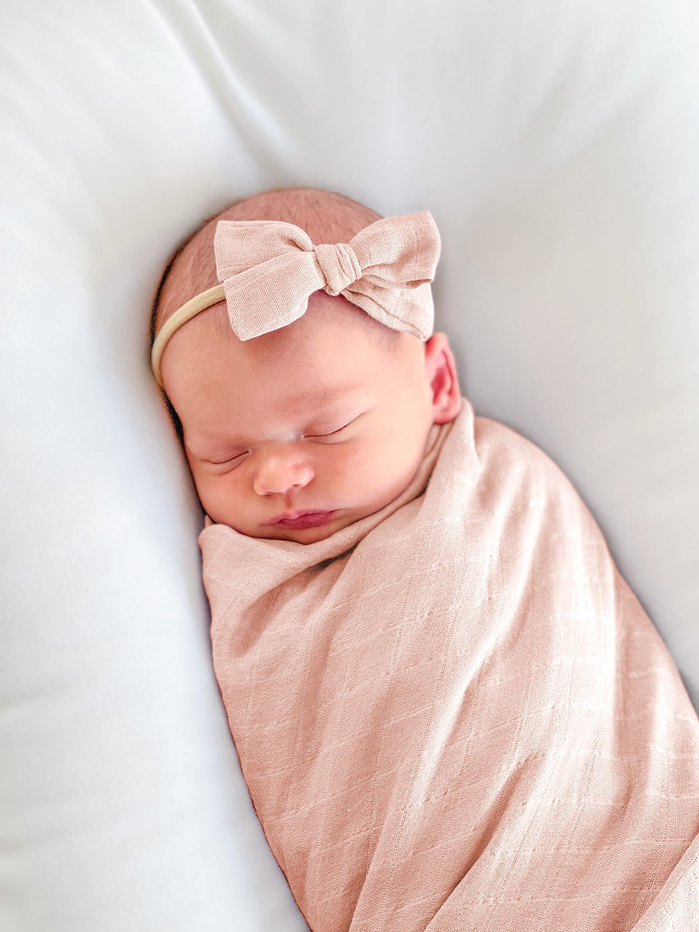 Baby Want Designs premium swaddle in dusty blush open, showing breathable fabric and generous 47-inch size.