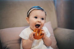 Calmies teether baby chewing action highlights gentle teething relief.
