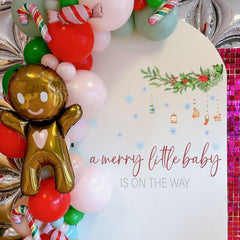 Capiont A Merry Little Baby On The Way decal wreath detail for festive baby shower backdrop.