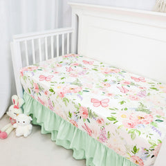 CARUILI ruffled crib skirt in green accents hides under-crib storage for a neat look.