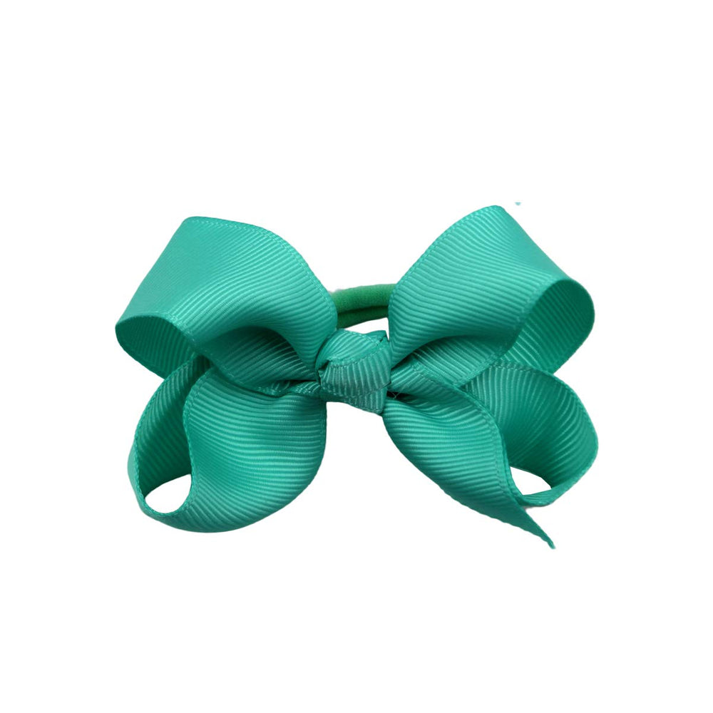 CÉLLOT boutique 3-inch green hair bow with elastic tie adds a playful touch.