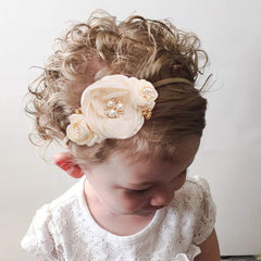 Cherrboll newborn headband with elastic-fit for easy wear during photos.