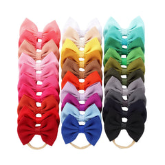 Cinaci bright color baby bows on stretchy nylon headbands offer easy outfit matching.
