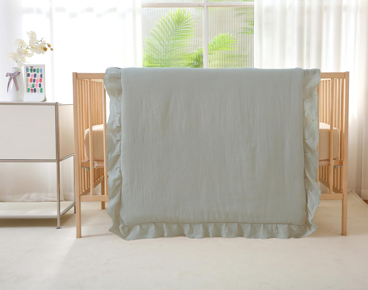 CLoucl muslin crib comforter with ruffle trim for a cozy nursery