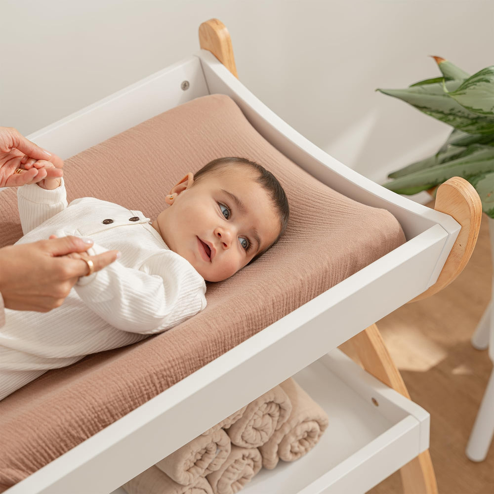 Comfy Cubs changing table white with natural legs fits with cribs and furniture for cohesive spaces.