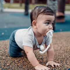 Comfy Cubs pacifier clips show soft colors on baby clothes for stylish practicality.