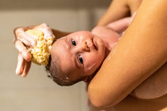 Contented Infant bath time setup with sponges highlights easy, comforting wash