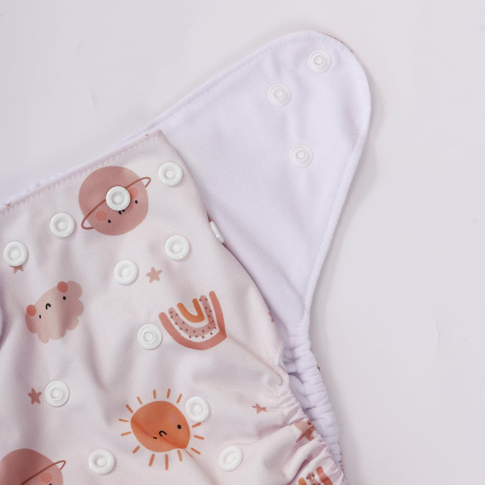 CoolaPeach pink cloth diaper set on baby demonstrates stylish, practical solution.