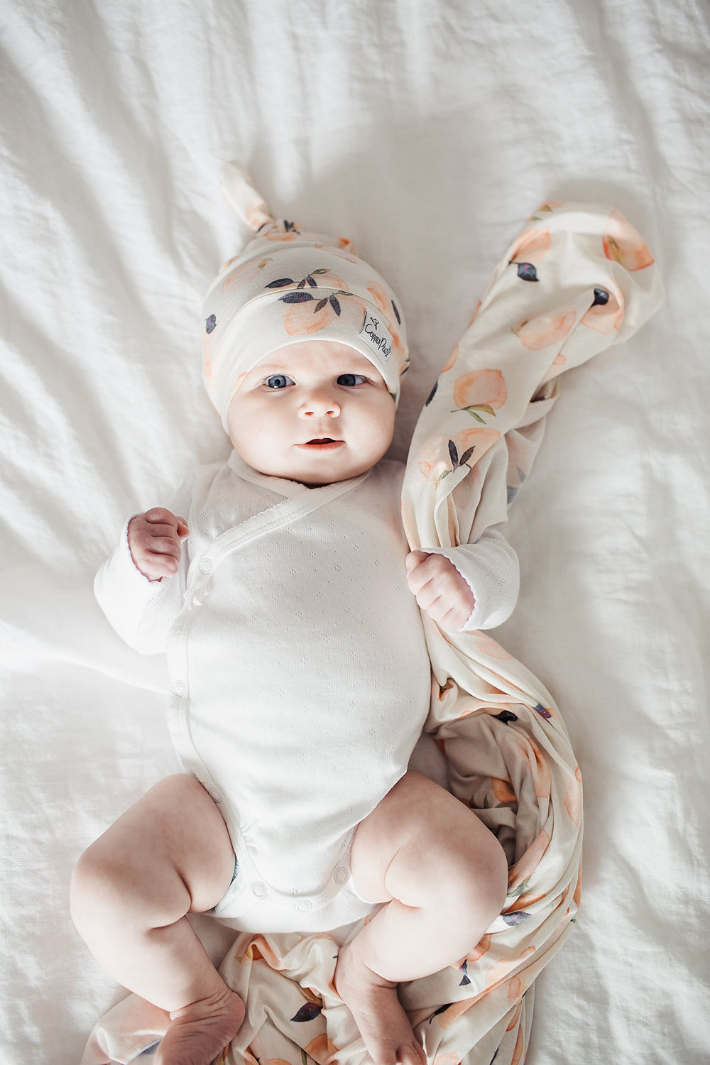 Copper Pearl Large Premium Knit Swaddle Caroline baby wearing the blanket, emphasizing breathable comfort.
