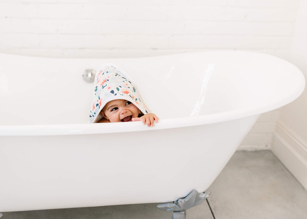 Copper Pearl Leilani hooded towel with tiny pockets to keep little hands warm.