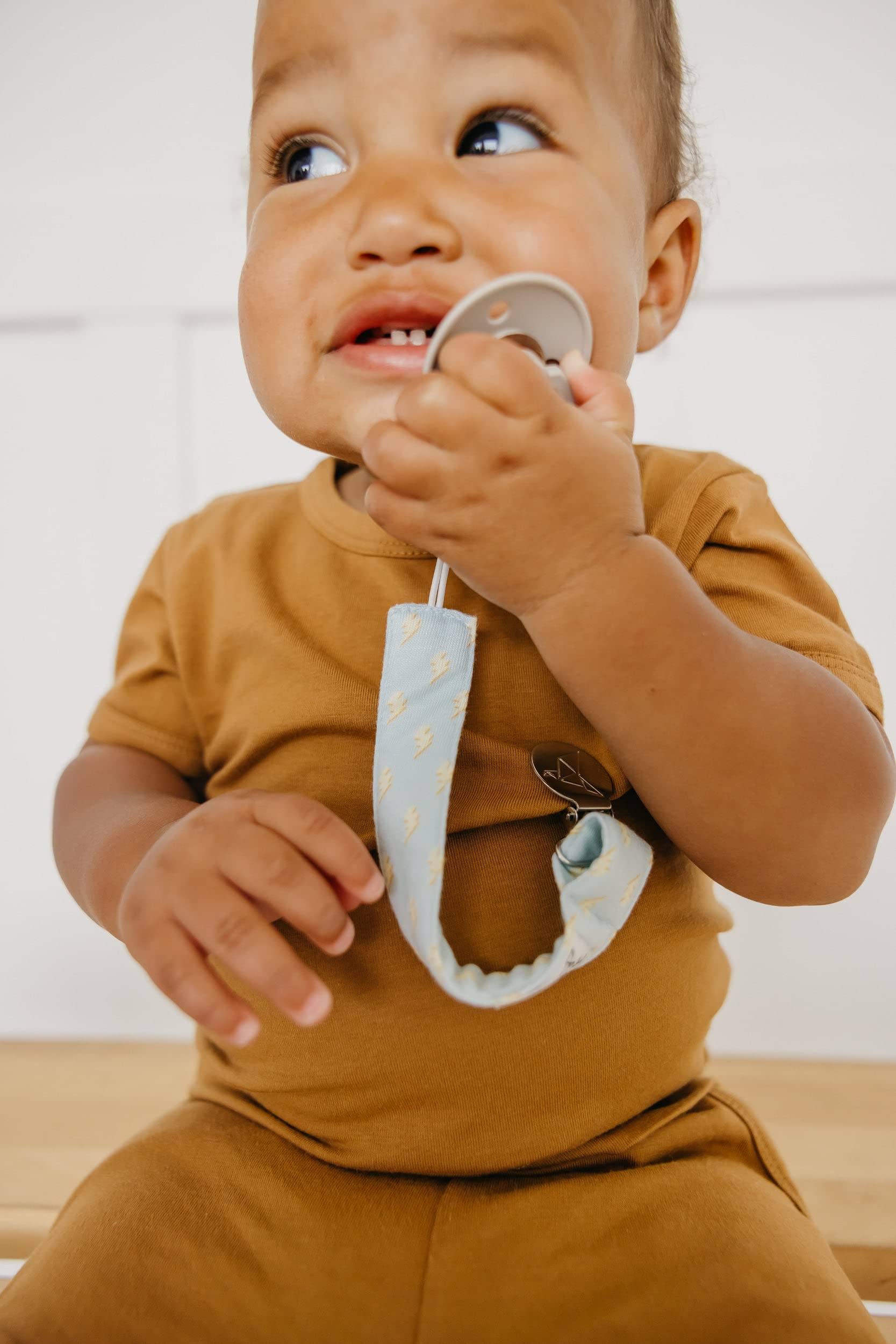 Copper Pearl pacifier clip durability close-up demonstrates fabric-safe gripping.
