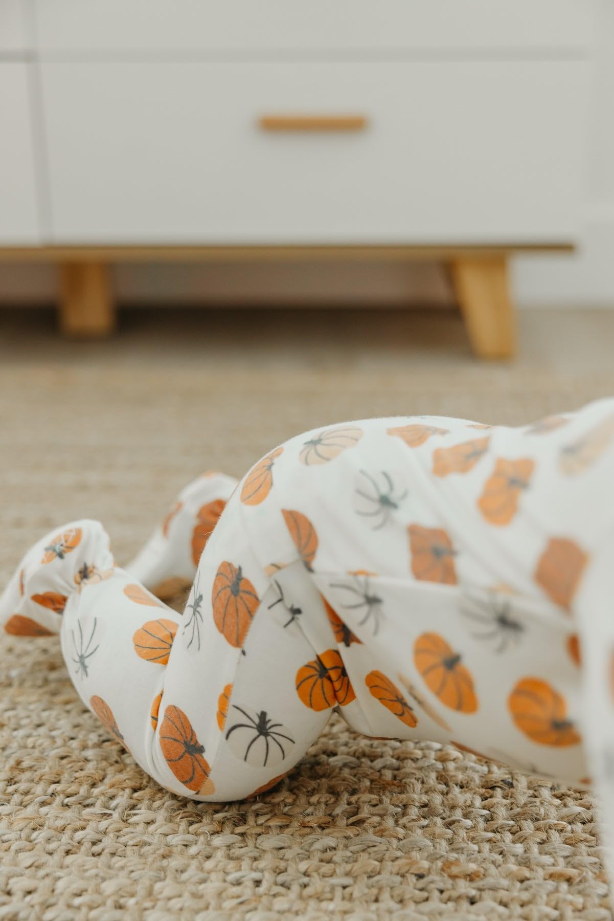 Copper Pearl zip-up footie pajama newborn-size option on tiny feet.