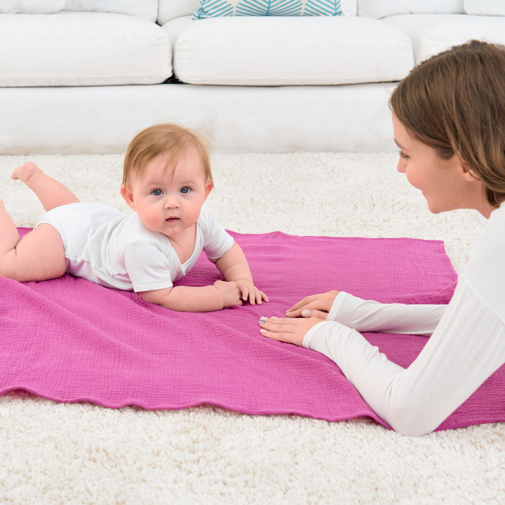 CottCare baby muslin swaddle rose pink swaddle style demonstrates simple, gentle infant wrapping.