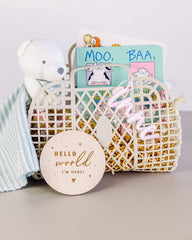 The Cotton and Canvas Co. nursery decor disc on shelf — adds timeless warmth.