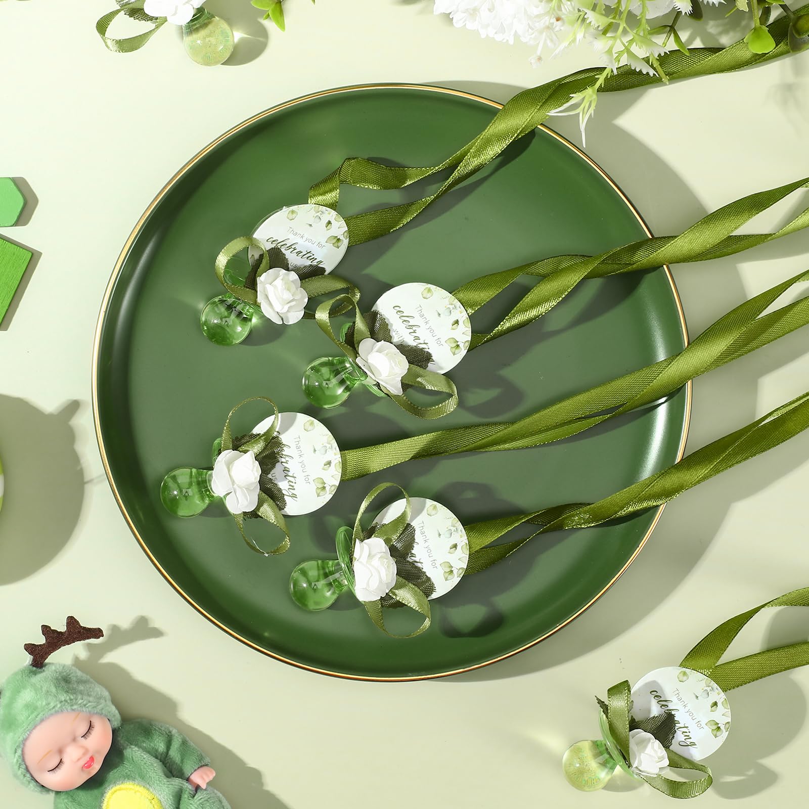 Coume baby shower favors table display — cohesive sage-green decor for the event.