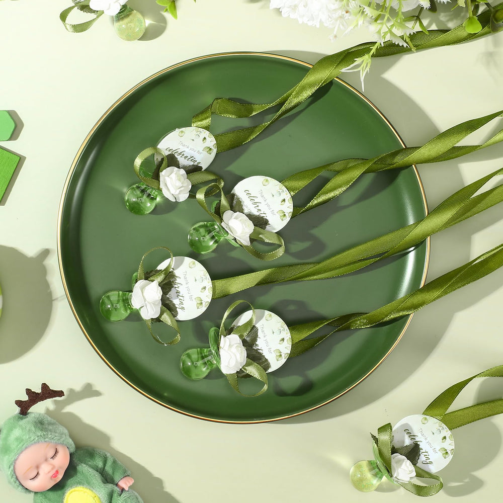 Coume baby shower favors table display — cohesive sage-green decor for the event.