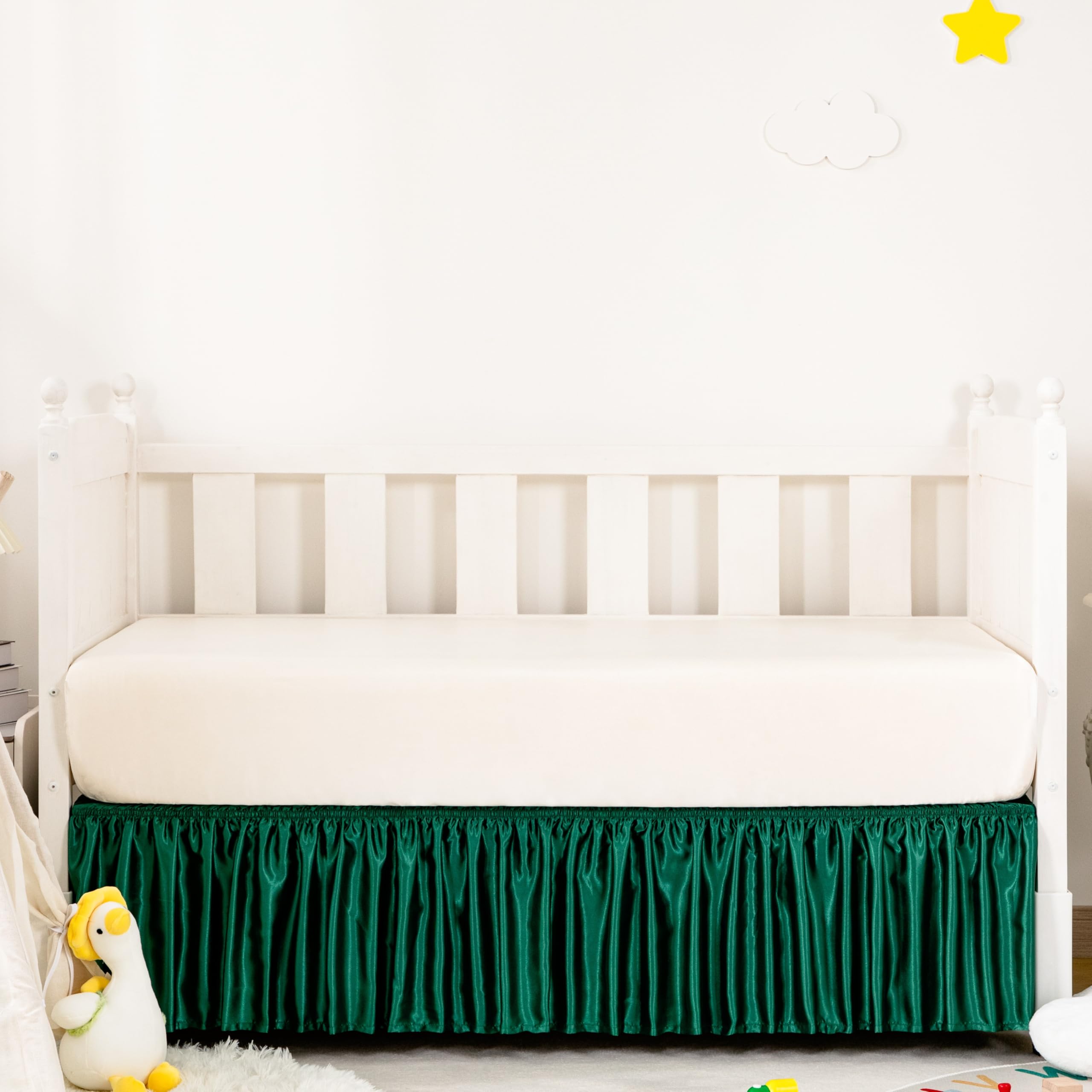 Counfeisly Blackish Green Satin Crib Skirt on bed offers silky touch for baby comfort.