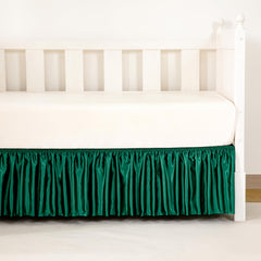 Counfeisly dust-ruffled crib skirt decor enhances nursery aesthetics.