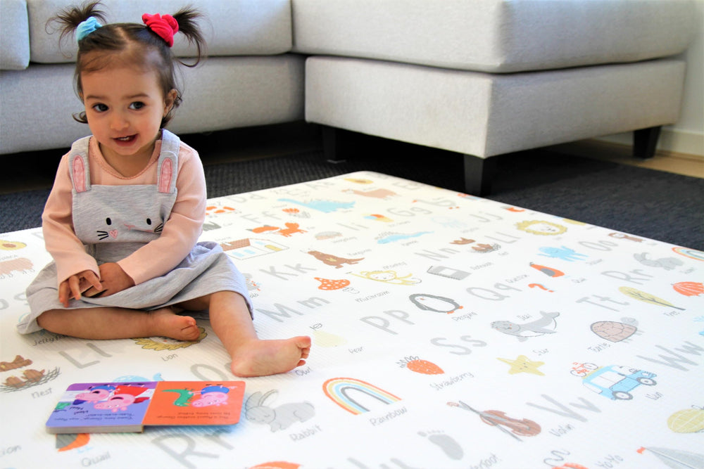 Cushmat alpha-palm-char play mat in use during toddler playtime on a cushioned surface