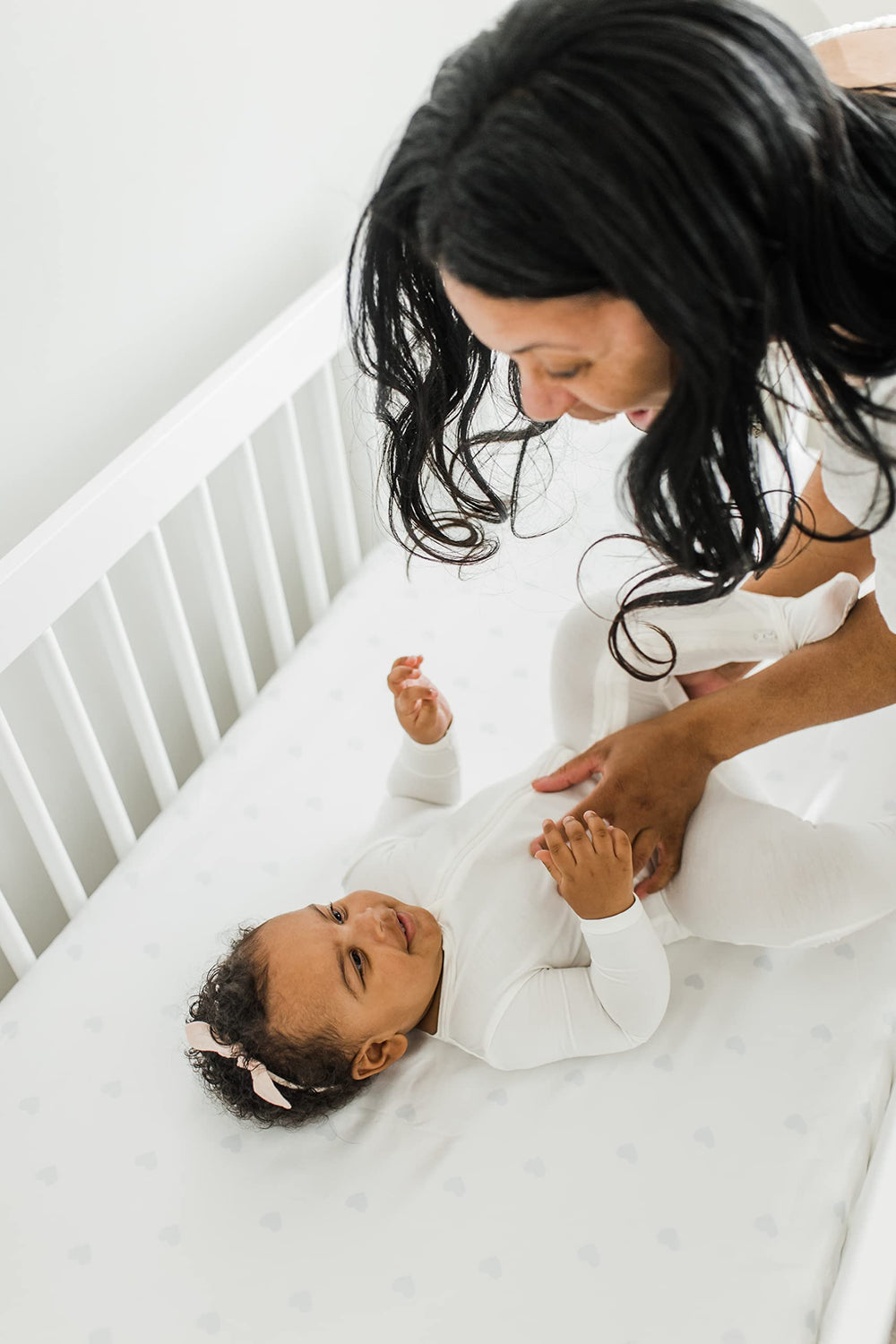CutieCozy satin sheet on crib mattress demonstrates secure fit for standard cribs.