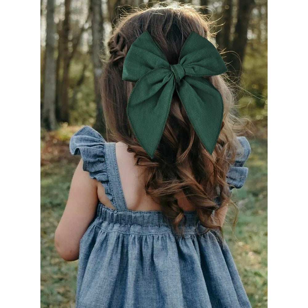 DEEKA model wears 4-inch bows in a bun for a tidy style.
