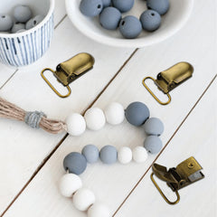 Demearly pacifier clip in use with bibs and toys for everyday organization