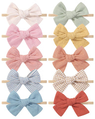 Doboi 10pcs headbands laid out with bows for newborn to toddler style inspiration.