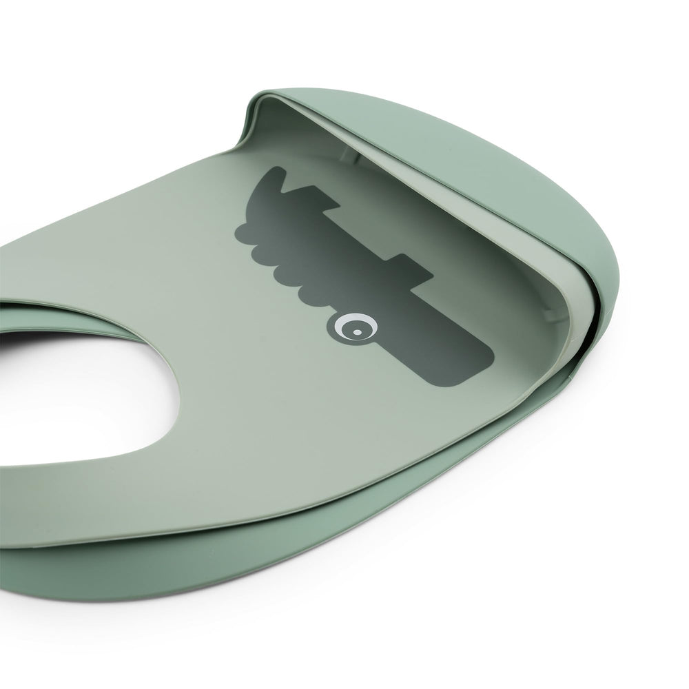 Done by Deer Croco Green silicone bib dishwasher-safe close-up shows easy cleanup.