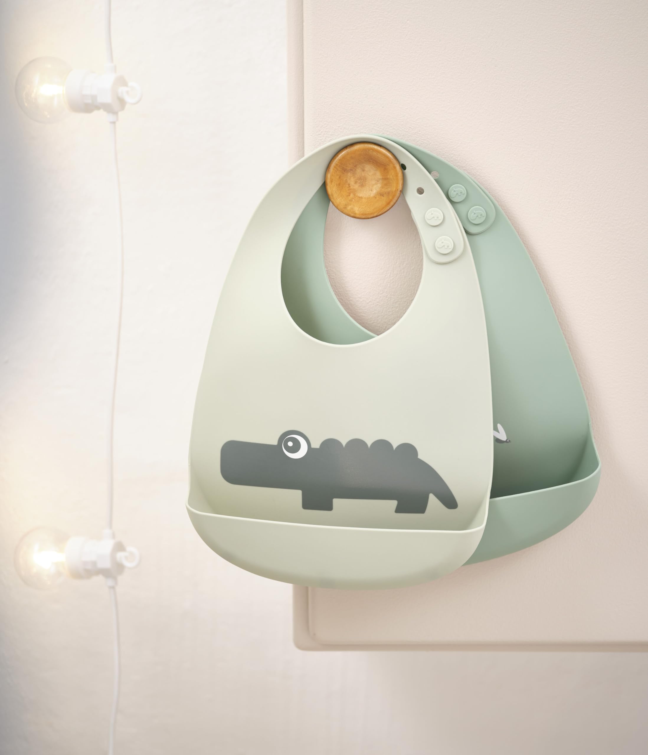 Done by Deer Croco Green silicone bib pocket close-up catching dropped food.