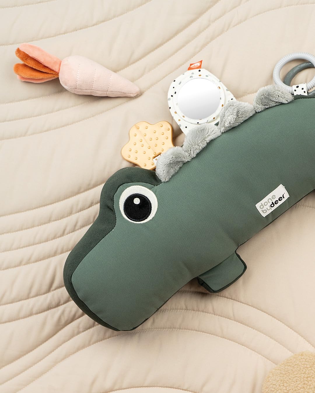 Done by Deer tummy time pillow colorful-tags close-up encourages tactile exploration.