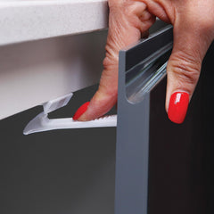 Dreambaby cabinet installation closeup highlights adhesive mounting on doors.