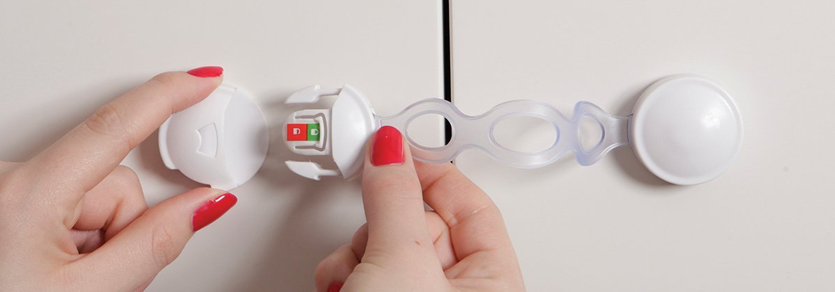 Dreambaby Ezy-Check latch adhesive-back view shows secure mounting on furniture.