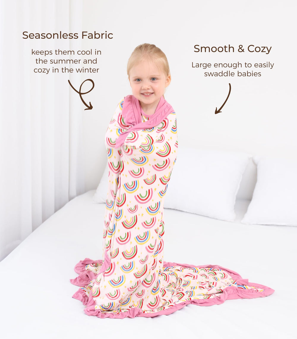 DREAMHALO crib bedding in nursery with rainbow-ruffle blanket accent.